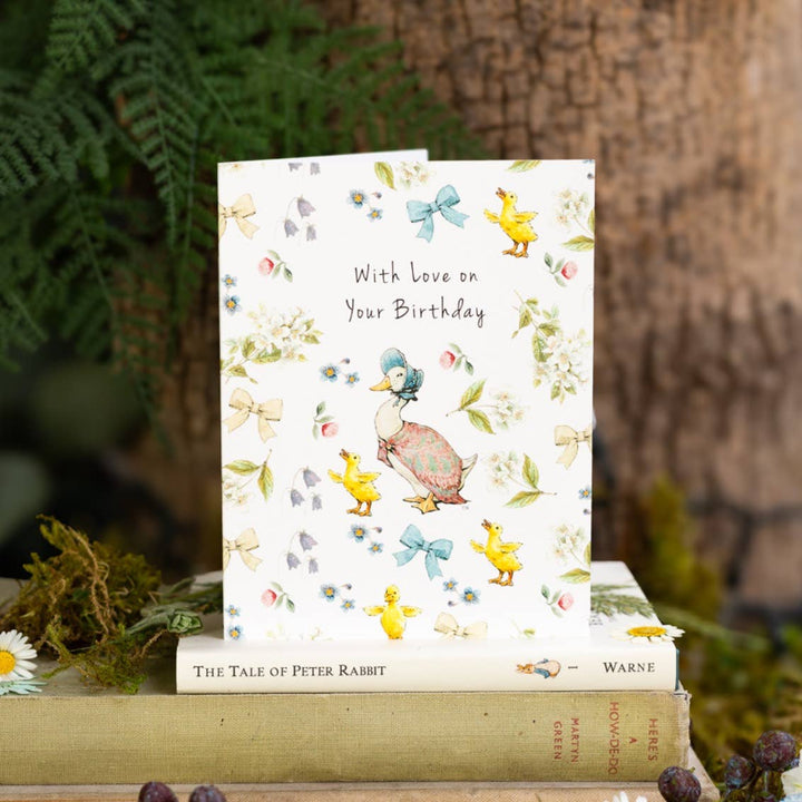 Love on Your Birthday (Jemima Puddle-Duck) Card - Magnolia the Florist Send your birthday wishes with this charming Love On Your Birthday Jemima Puddle-Duck Card, featuring the beloved Beatrix Potter character. Perfect for someone special, this beautifully illustrated card adds a thoughtful finishing touch to any gift or flower delivery. Size is 108 × 140 mm • Blank inside • Includes kraft envelope  1