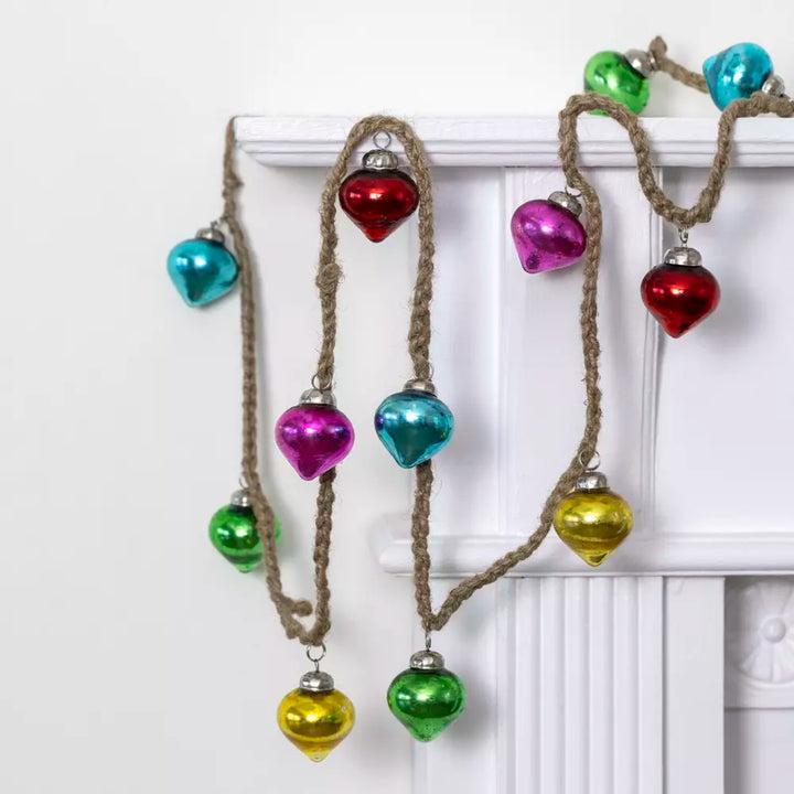 Rainbow Bauble Garland - 160cm - Magnolia the Florist Add a splash of colour to your holiday décor with our mini bauble garland. Featuring a delightful mix of pink, turquoise, gold, and green baubles, this charming decoration is perfect for brightening up any space. Ideal for draping across mantels, staircases, or around your Christmas tree, it brings festive cheer in an instant. Dimensions: 160 cm - Glass  1