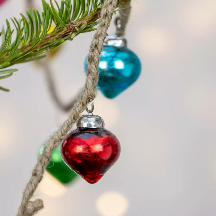 Rainbow Bauble Garland - 160cm - Magnolia the Florist Add a splash of colour to your holiday décor with our mini bauble garland. Featuring a delightful mix of pink, turquoise, gold, and green baubles, this charming decoration is perfect for brightening up any space. Ideal for draping across mantels, staircases, or around your Christmas tree, it brings festive cheer in an instant. Dimensions: 160 cm - Glass  4