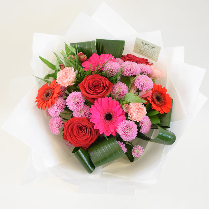 the Buckingham Bouquet from Magnolia the Florist,&amp;nbsp; features a stunning combination of red and pink-toned flowers, including roses, gerbera, alstroemeria, carnation, chrysanthemum, and foliage