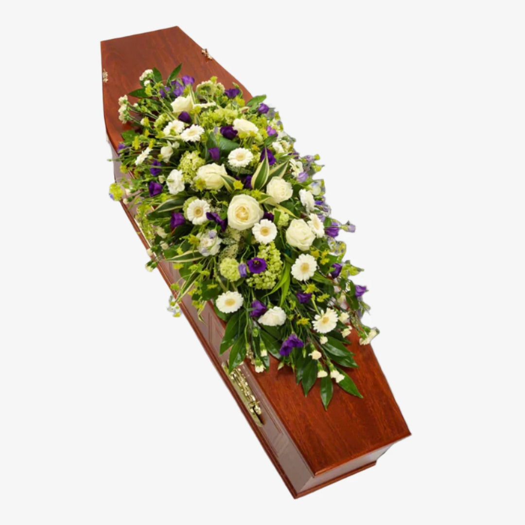 White & Purple Casket Spray - Magnolia the Florist A gorgeous white casket spray interspersed with purple Lisianthus blooms. White Roses, Germini, Carnations and Viburnum are lovingly arranged with an assortment of foliage. If you cannot find what you want on our site, please call our sales team, we're always happy to assist you This item requires 2 days notice to order. (Please note this item is only available in our local delivery area. See our delivery page for more information).  1