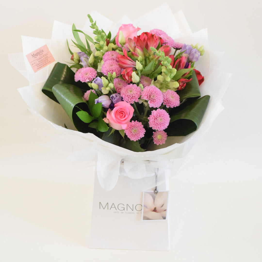 Chelsea Bouquet - Magnolia the Florist Our Chelsea Bouquet from Magnolia the Florist, is a stunning combination of pink, white, and a hint of purple flowers, including roses, antirrhinum, lisanthus, alstromeria, and chrysanthemum. It is perfect for any occasion.  2
