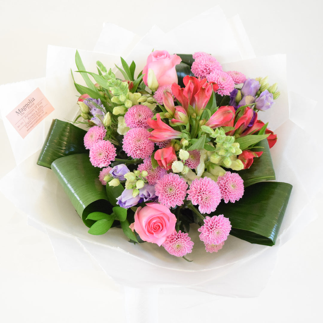 Chelsea Bouquet - Magnolia the Florist Our Chelsea Bouquet from Magnolia the Florist, is a stunning combination of pink, white, and a hint of purple flowers, including roses, antirrhinum, lisanthus, alstromeria, and chrysanthemum. It is perfect for any occasion.  1