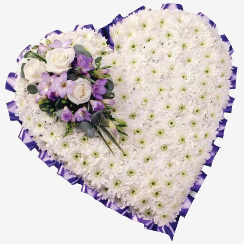 Based Heart - Magnolia the Florist A 15" classic heart-shaped design covered with a mass of white Double Spray Chysanthemums and finished with a spray of coloured flowers. The image shows a spray colour selection of Lilac, though other colour options are available. Please select your option below. If you cannot find what you want on our site, please call our sales team, we're always happy to assist you This item requires 2 days notice to order.  1