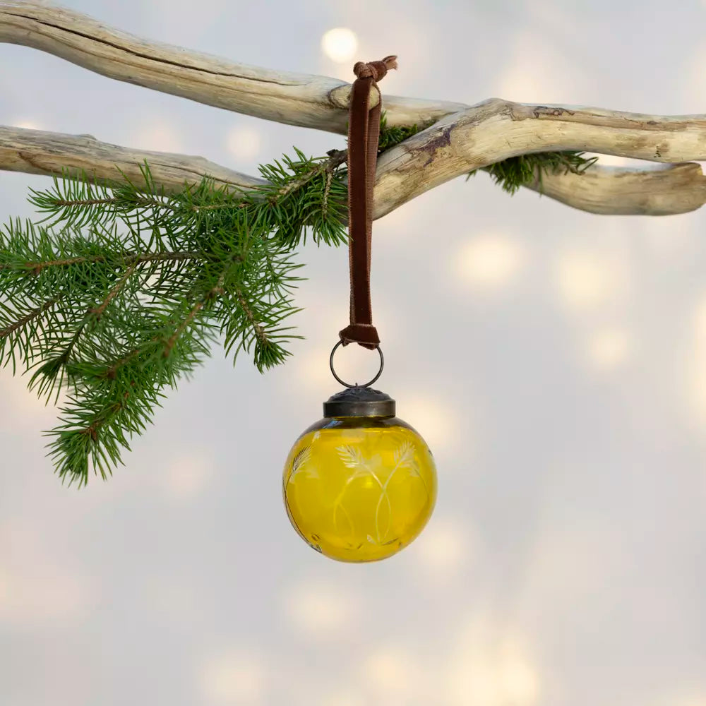 Etched Round Decoration  - Yellow - 5cm - Magnolia the Florist Add a touch of sophistication to your Christmas tree with this exquisite round hanging decoration. Crafted from glass in a charming yellow hue, this bauble features an elegant etched pattern that catches the light beautifully. Measuring 5cm in diameter, it is the perfect size for adding subtle elegance to your festive display. This beautiful bauble is sure to bring warmth and a playful style to your celebrations. Dimensions: 5 cm - Glass  1