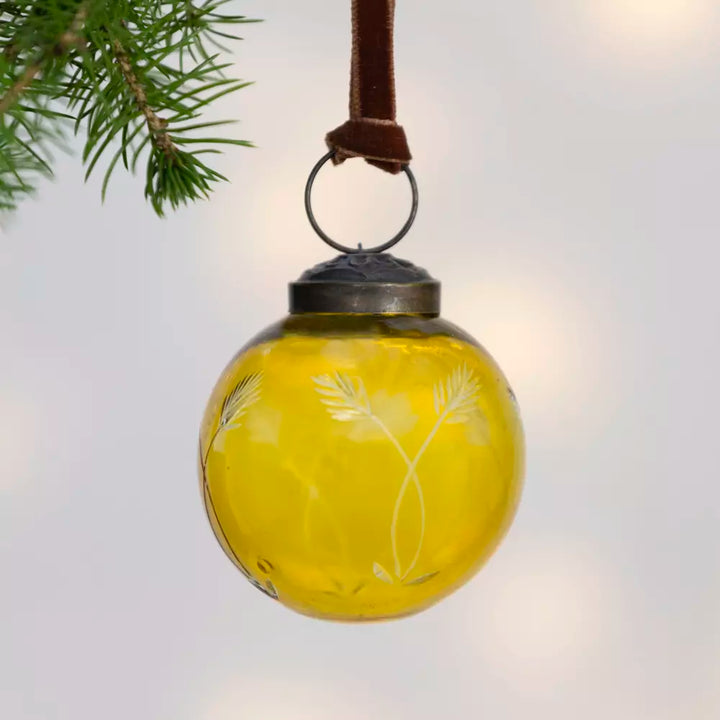 Etched Round Decoration  - Yellow - 5cm - Magnolia the Florist Add a touch of sophistication to your Christmas tree with this exquisite round hanging decoration. Crafted from glass in a charming yellow hue, this bauble features an elegant etched pattern that catches the light beautifully. Measuring 5cm in diameter, it is the perfect size for adding subtle elegance to your festive display. This beautiful bauble is sure to bring warmth and a playful style to your celebrations. Dimensions: 5 cm - Glass  4