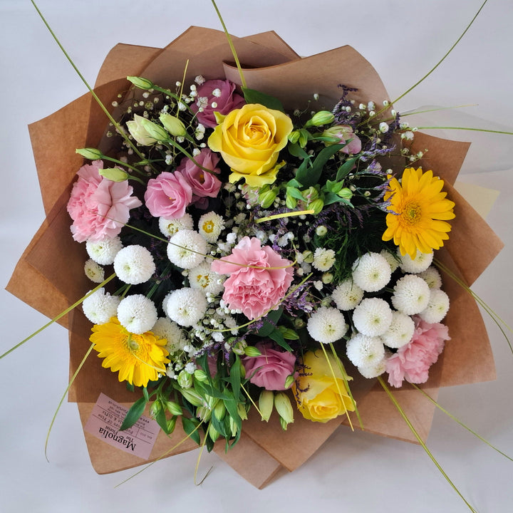 Lilford Bouquet - Magnolia the Florist The Lilford Bouquet is an expertly crafted hand-tied arrangement showcasing a refined blend of Germini, Roses, Alstroemeria, Eustoma, Carnation, Gyp, Chrysanthemums, and Statice in harmonious shades of pink, yellow, and white. Finished with lush greenery, this bouquet balances texture and colour to create a sophisticated, elegant statement suitable for any occasion.  2