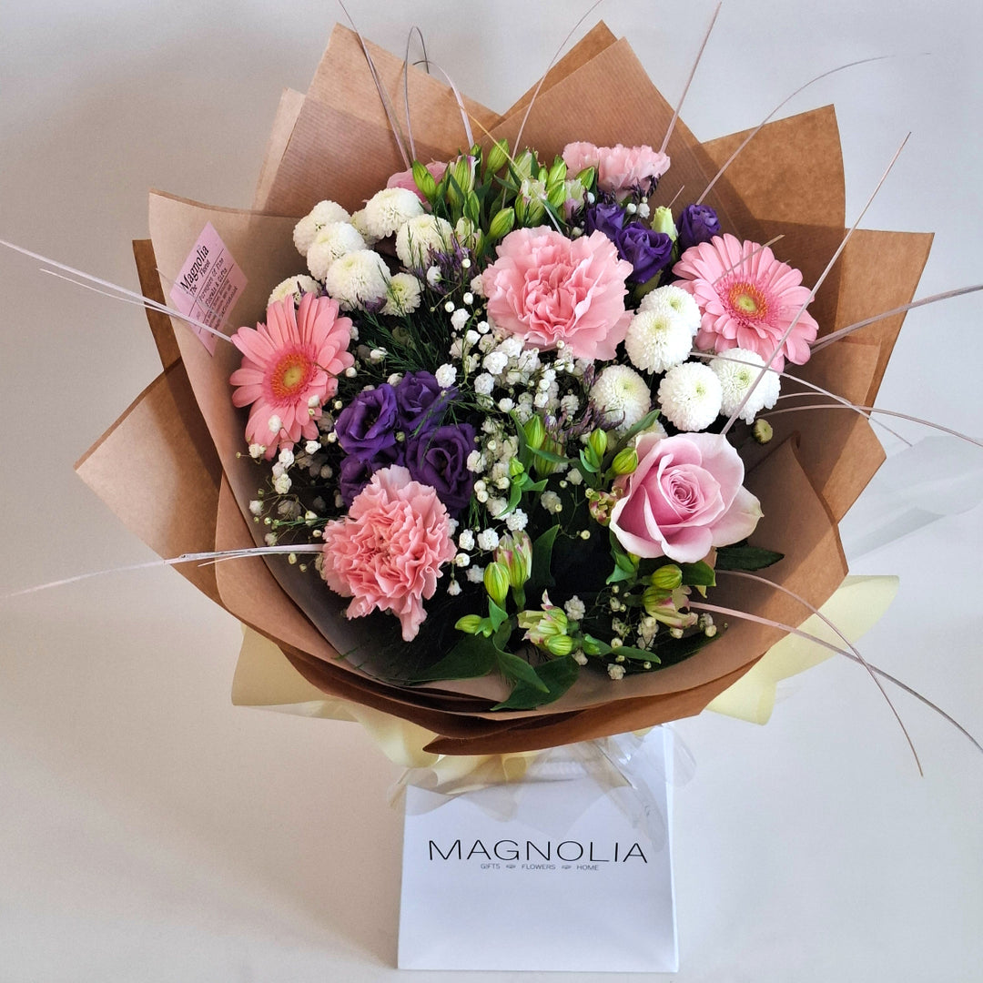 Warkton Bouquet - Magnolia the Florist The Warkton Bouquet is an expertly crafted, hand-tied arrangement that blends Germini, Eustoma, Alstroemeria, Roses, Gypsophila, Chrysanthemums, and Statice in harmonious shades of pink, white, and purple. Accented with fresh greenery, this bouquet offers a refined balance of texture and colour, perfect for conveying elegance and thoughtful sentiment on any occasion.  1