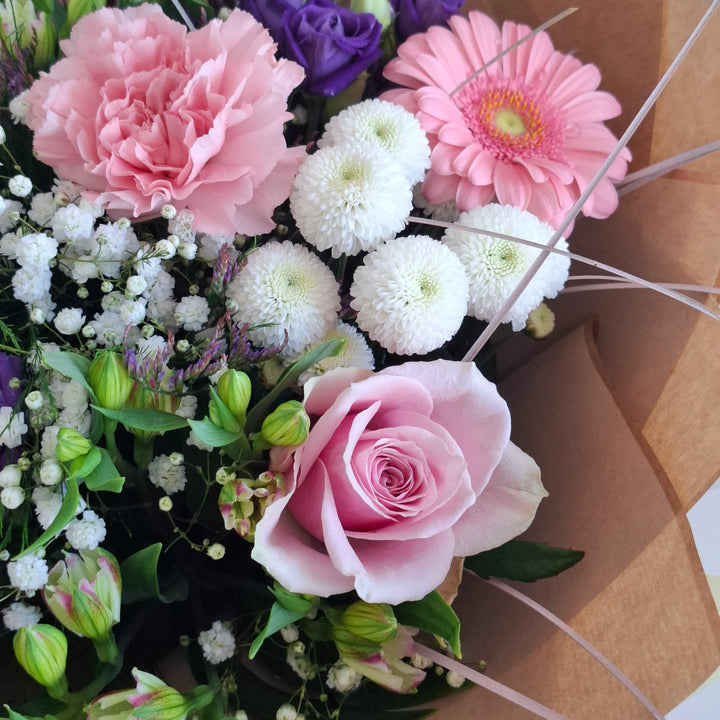 Warkton Bouquet - Magnolia the Florist The Warkton Bouquet is an expertly crafted, hand-tied arrangement that blends Germini, Eustoma, Alstroemeria, Roses, Gypsophila, Chrysanthemums, and Statice in harmonious shades of pink, white, and purple. Accented with fresh greenery, this bouquet offers a refined balance of texture and colour, perfect for conveying elegance and thoughtful sentiment on any occasion.  3