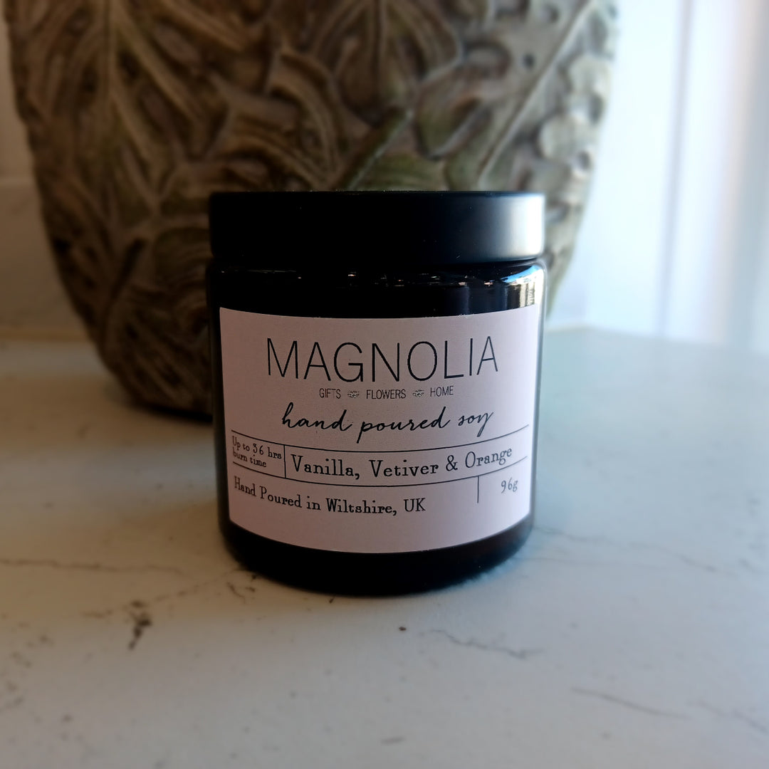 Vanilla, Vetiver & Orange Scented Candle - 96g - Magnolia the Florist Experience the soothing and uplifting aromas of our Vanilla, Vetiver & Orange Scented Candle. This candle brings together the warmth of vanilla, the earthiness of vetiver, and the refreshing notes of orange. Relax and indulge in a truly luxurious sensory experience. Enjoy the aromatic benefits while enhancing any room with a touch of elegance, made with a professional blend of scented oil & emollient wax balm.  1