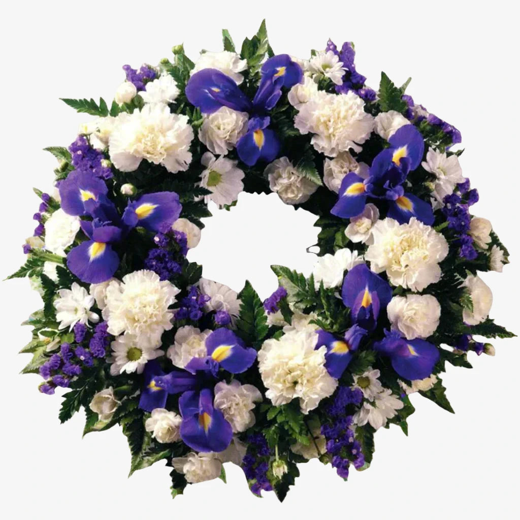 Purple & White Wreath - Magnolia the Florist A classic selection of flowers including Irises, Carnations and Spray Chrysanthemums in purple and whites are nestled into this traditional circular wreath. If you cannot find what you want on our site, please call our sales team, we're always happy to assist you This item requires 2 days notice to order.  1