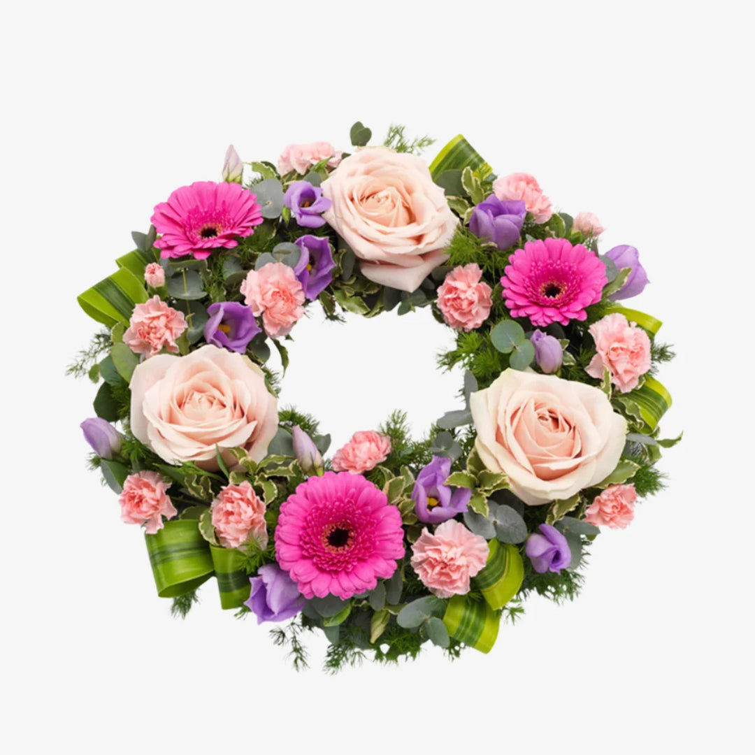 Pink Wreath - Magnolia the Florist A pretty pink wreath featuring Roses, Germini and Carnations with lilac Lisianthus and mix of luscious green foliage. If you cannot find what you want on our site, please call our sales team, we're always happy to assist you This item requires 2 days notice to order.  1