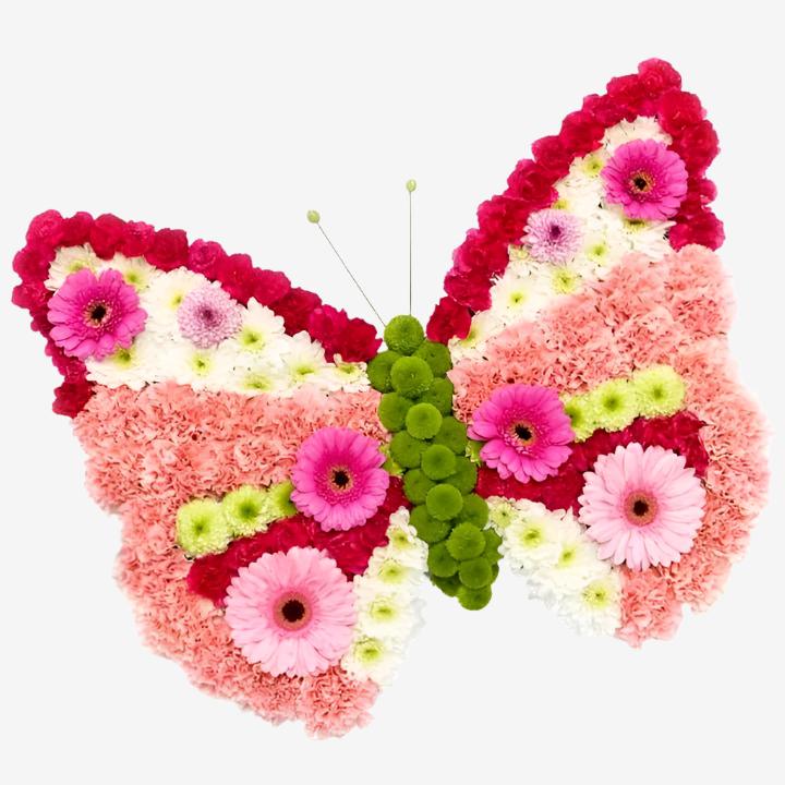 Butterfly - Magnolia the Florist A pretty pink butterfly wreath in fresh flowers. Approx Size is 20" x 23" If you cannot find what you want on our site, please call our sales team, we're always happy to assist you This item requires 5 days notice to order.  1
