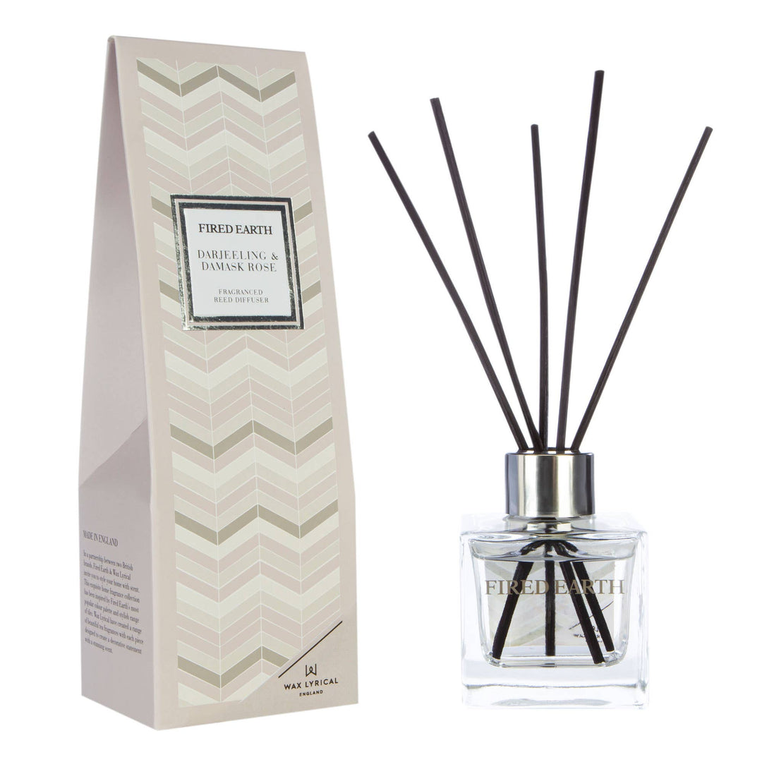 Fired Earth Reed Diffuser 100ml, Darjeeling & Damask Rose - Magnolia the Florist This compact Darjeeling and Damask Rose Reed Diffuser from Wax Lyrical fills your space with a sophisticated blend. Part of the Fired Earth collection, as the black reeds soak up the oil a captivating melody of oud, delicate rose, jasmine, and cedarwood transports your to a world of elegance.  1